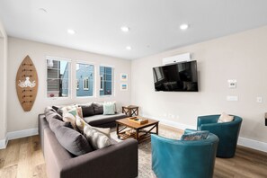Un salon moderne avec un canapé, une table basse et un téléviseur fixé au mur.