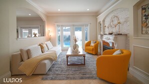 Un salon comprenant un canapé, deux fauteuils, une table basse et une cheminée.