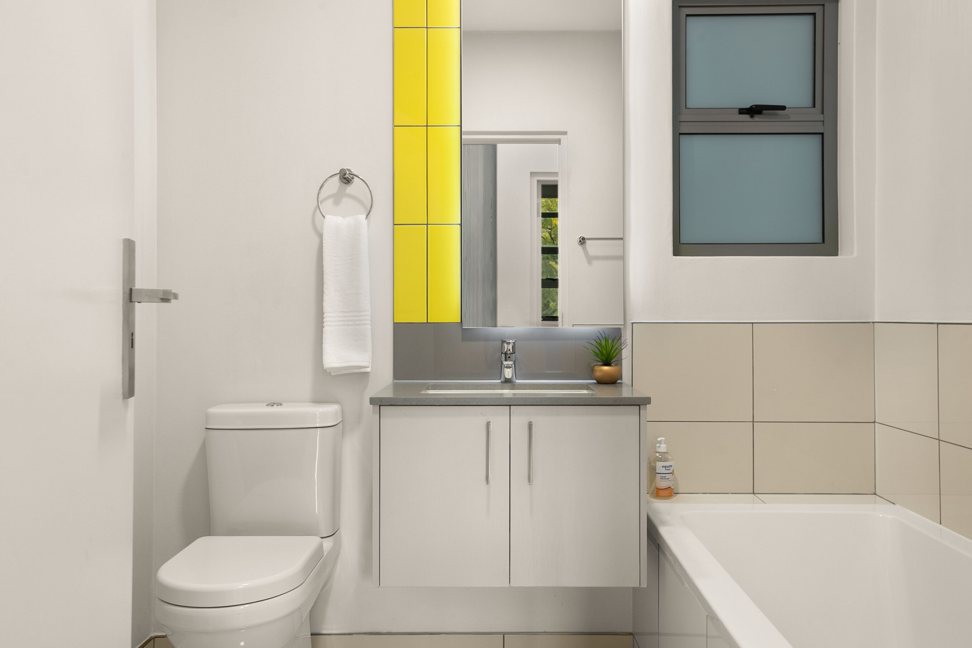 Ein modernes Badezimmer mit Toilette, Waschbecken und Badewanne.
