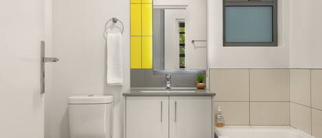 A modern bathroom with a toilet, sink, and bathtub.