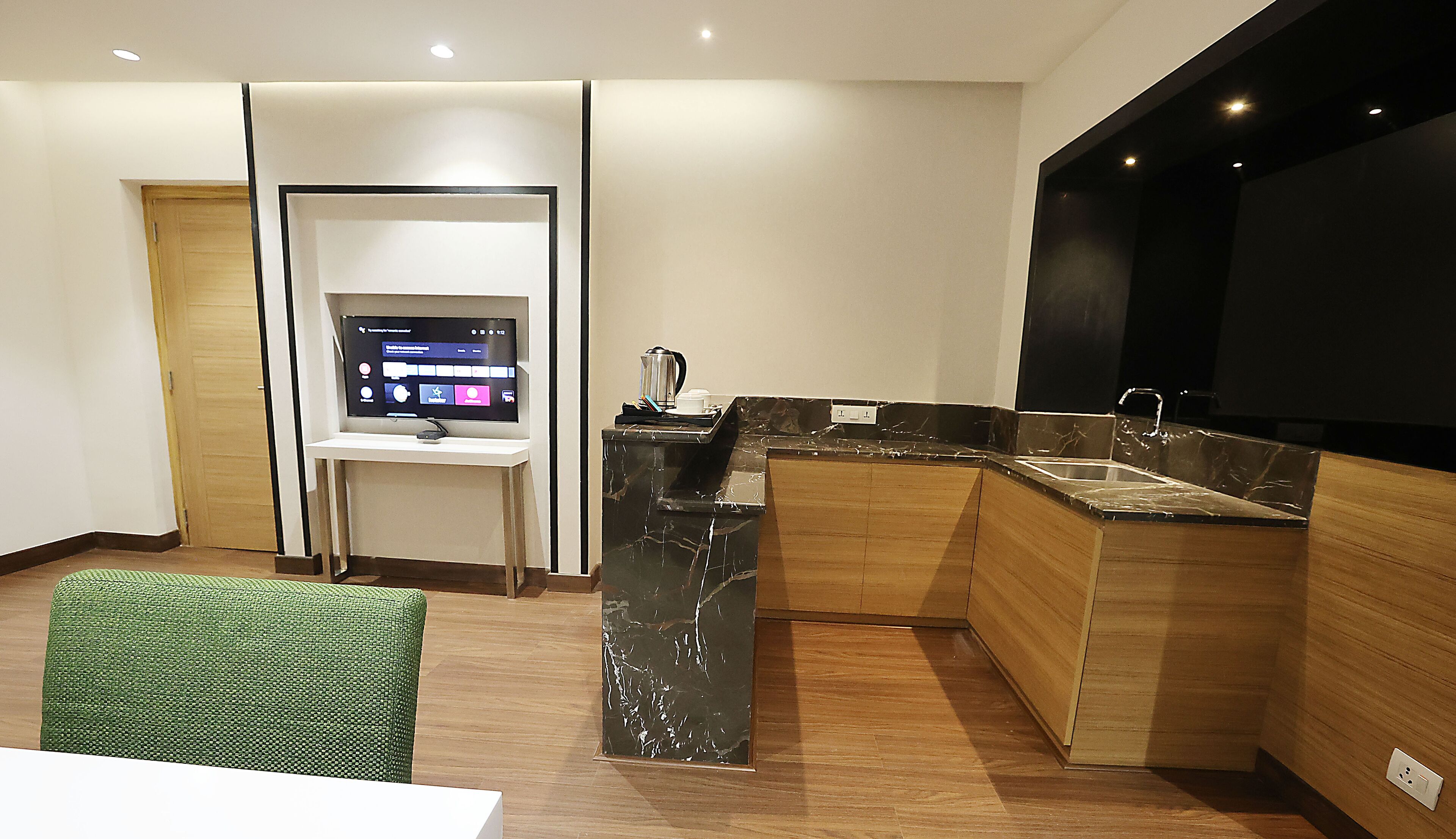 A modern kitchen with a built-in TV, a coffee maker, and a sink.