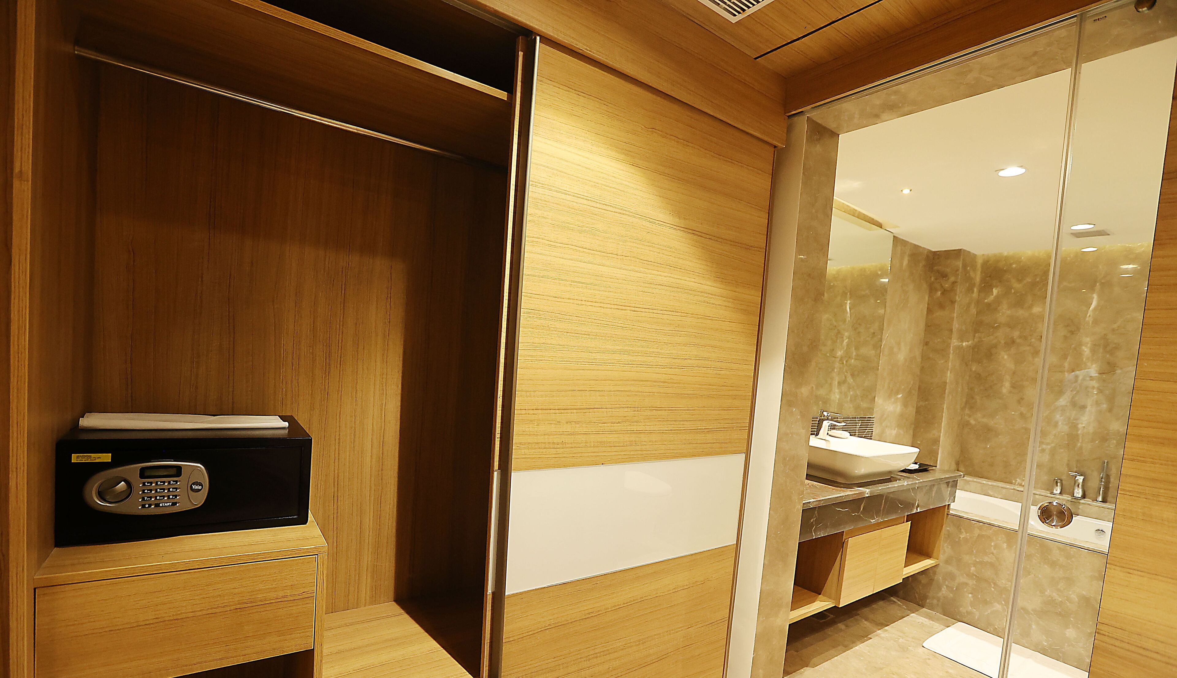 Un baño moderno con tocador de madera, radio empotrada y cabina de ducha de vidrio.