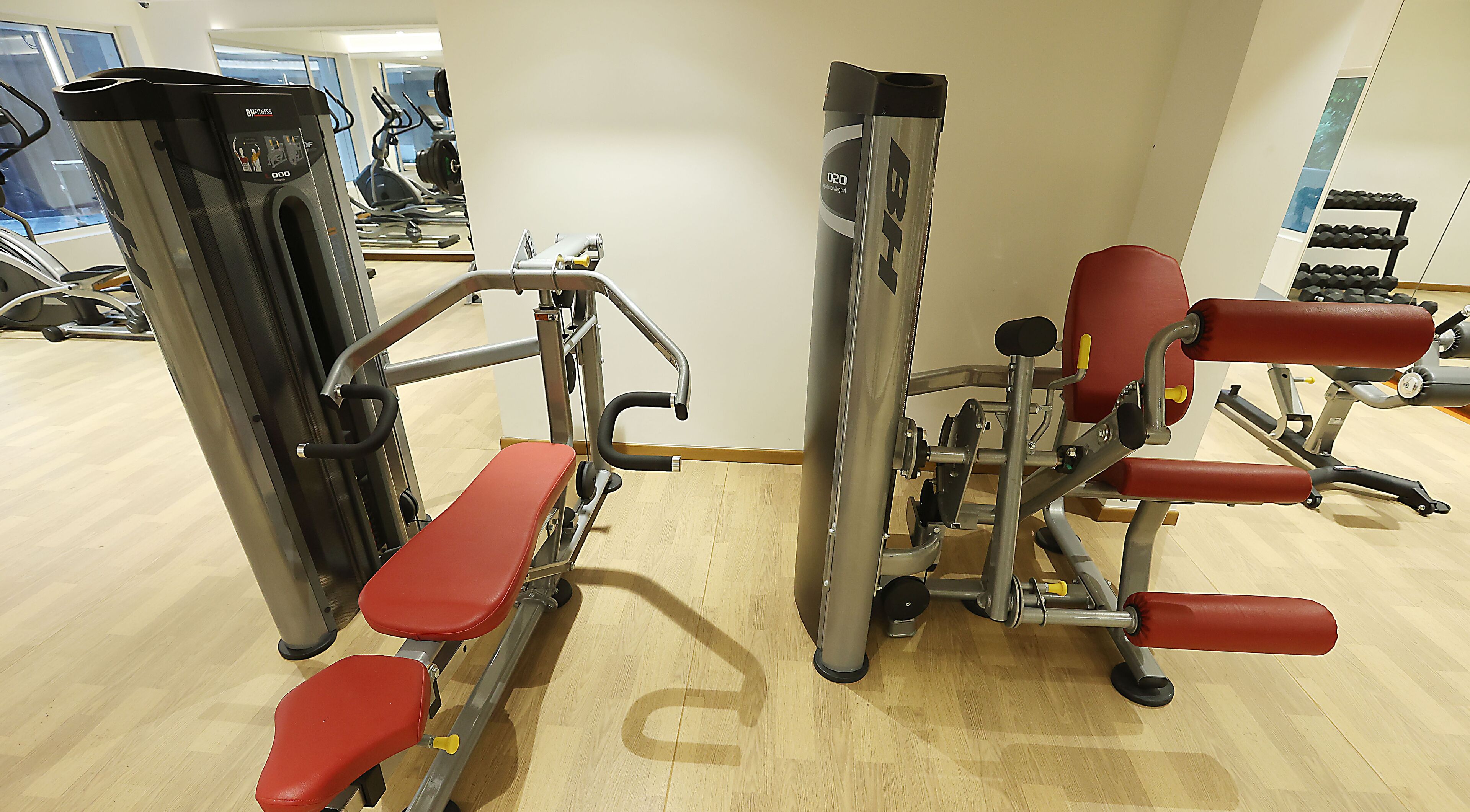 A gym with various exercise machines, including a bench press and a leg press.