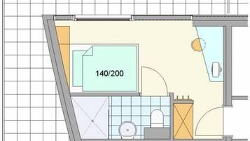 A floor plan of a hotel room with a bathroom, a kitchenette, and a seating area.