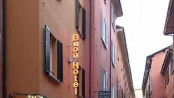 Una stretta via fiancheggiata da edifici, uno dei quali mostra un cartello con su scritto "Buon Hotel".