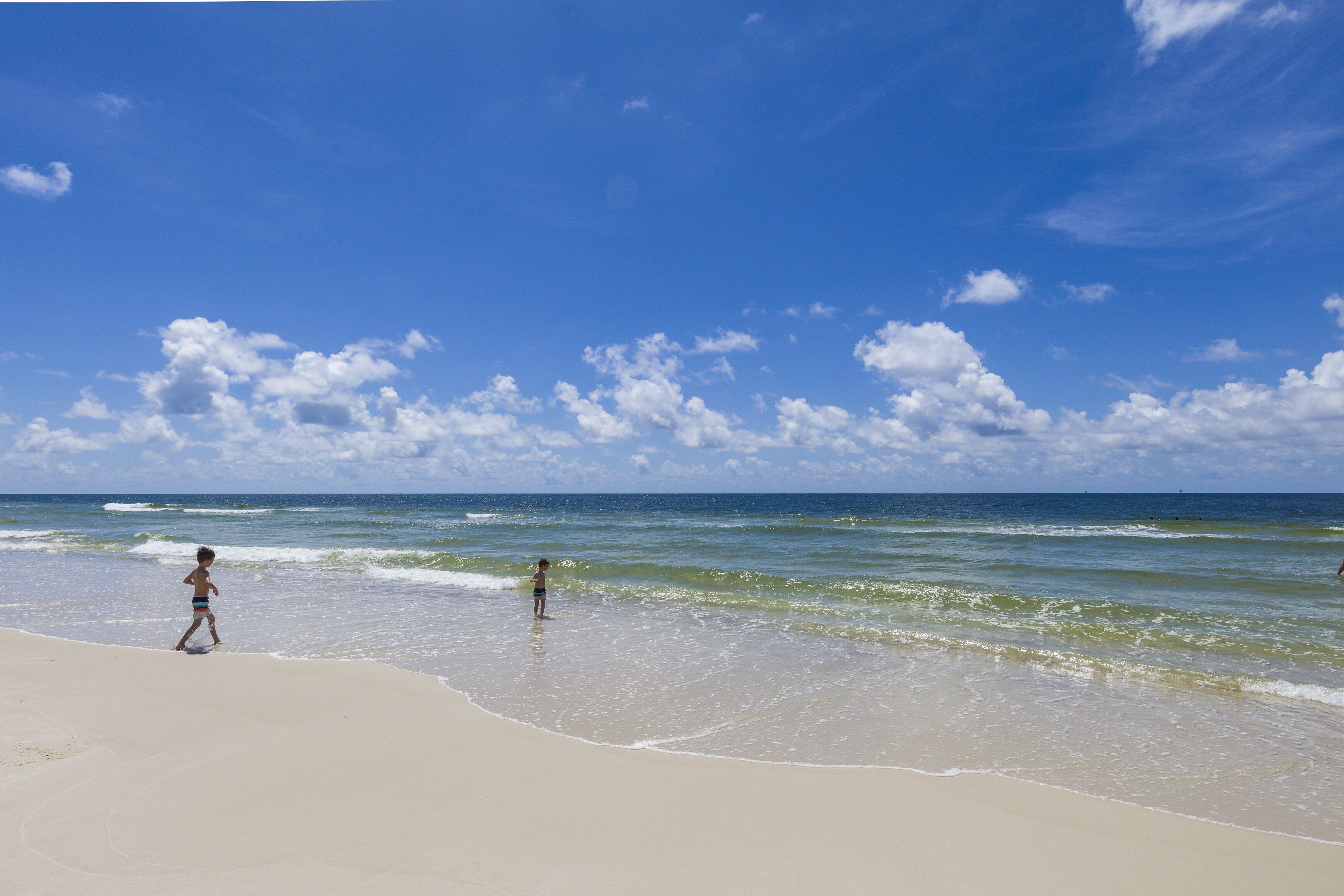 Una playa con cielos despejados y olas.