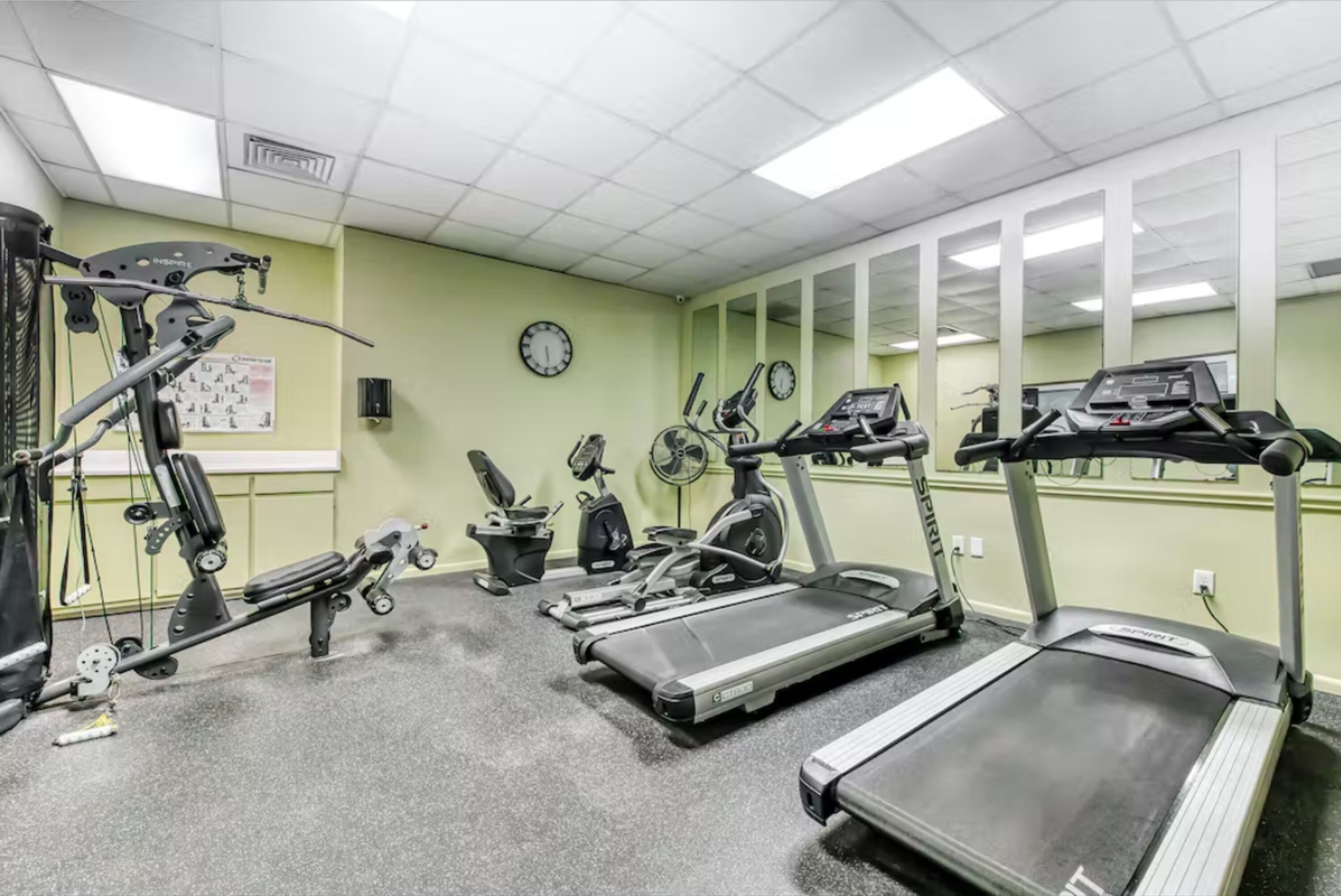 A gym with treadmills, elliptical machines, and a stationary bike.
