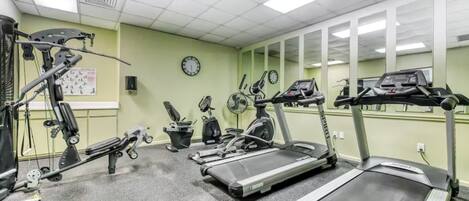 A gym with treadmills, elliptical machines, and a stationary bike.