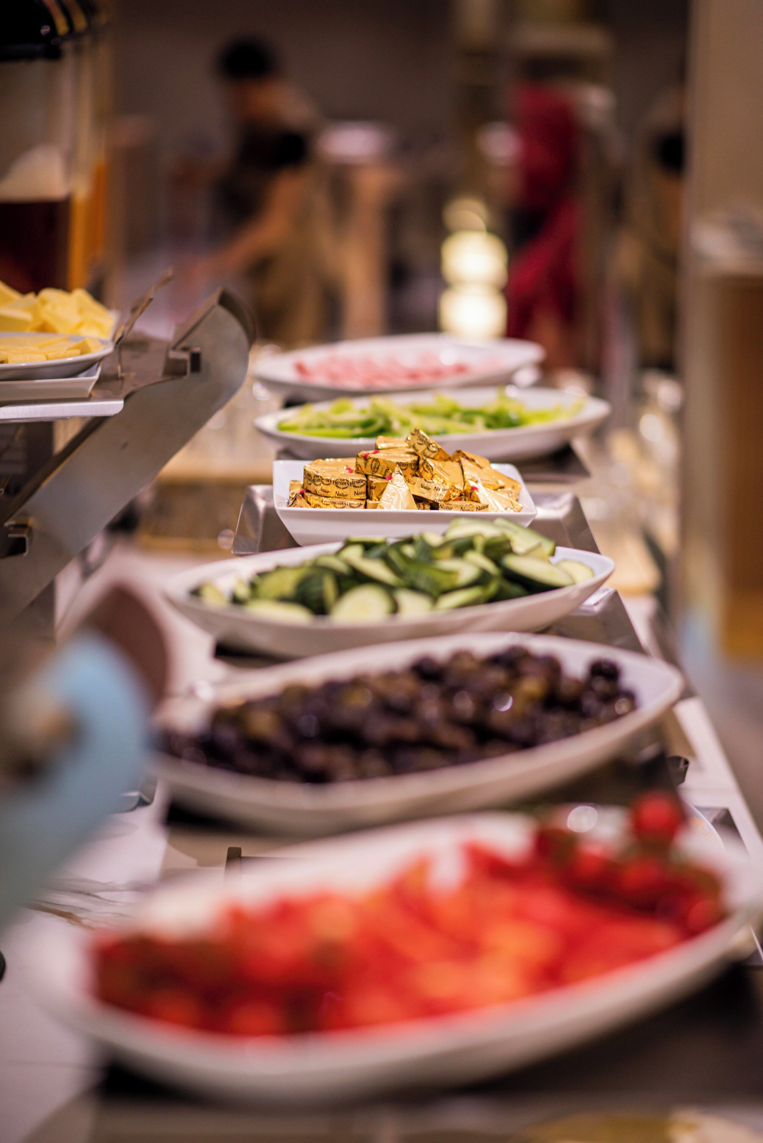 Una barra de buffet con distintos platos, incluyendo ensaladas, frutas y postres.