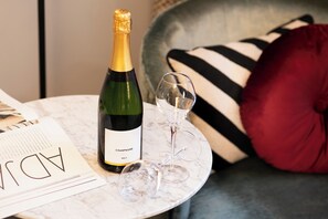 A bottle of champagne and two glasses on a marble table, with a magazine and a striped pillow in the background. - Maison ELLE Amsterdam (Amsterdam)