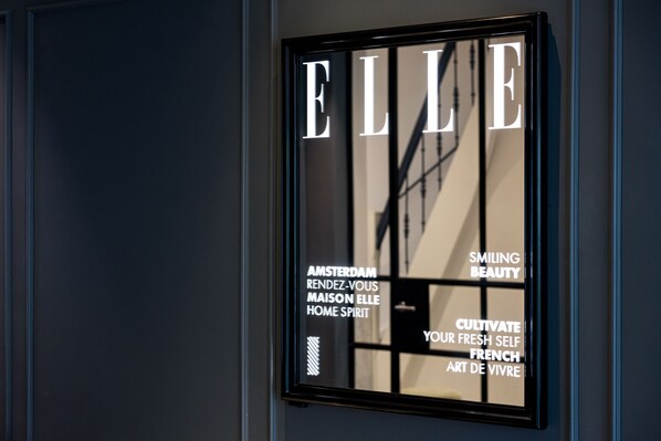 A framed sign with the word "ELLE" and text related to Amsterdam and French art. - Maison ELLE Amsterdam (Amsterdam)