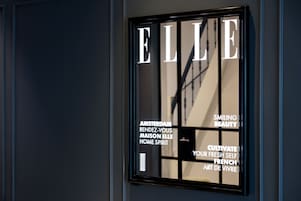 Un letrero enmarcado con la palabra "ELLE" y texto relacionado con Ámsterdam y el arte francés.