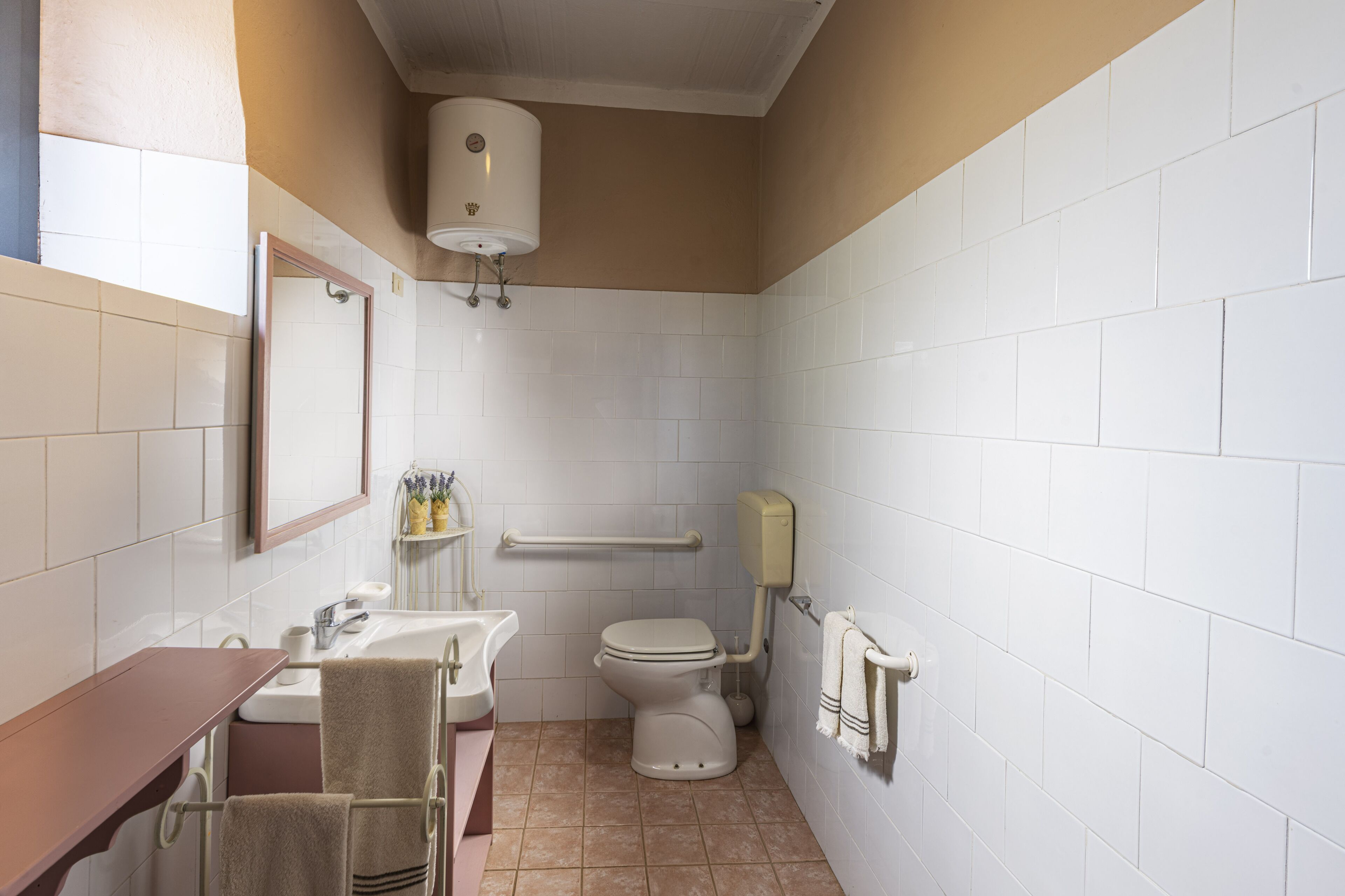 A small bathroom with a toilet, sink, and mirror.