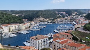 A marina with numerous boats docked, surrounded by buildings with red-tiled roofs. - Casa di Leccia, Superb villa close to the beach, private swimming pool (Lecci)
