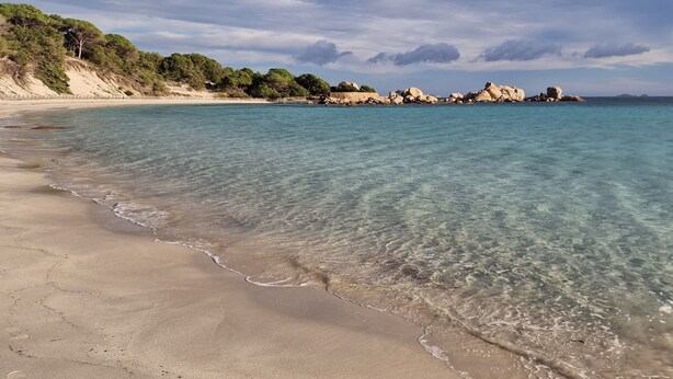 A beach with clear turquoise water, sandy shore, and rocky outcrops in the background. - Casa di Leccia, Superb villa close to the beach, private swimming pool (Lecci)