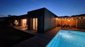 A modern outdoor pool area with a wooden deck, a covered seating area with string lights, and a clear view of the pool. - Casa di Leccia, Superb villa close to the beach, private swimming pool (Lecci)