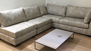 A sectional sofa with a white coffee table in front. - Il Bosco Segreto, where magic and history come together (Torino)