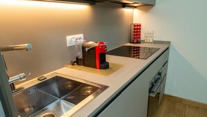 A modern kitchen with a built-in stove, a sink, and a countertop. - Il Bosco Segreto, where magic and history come together (Torino)