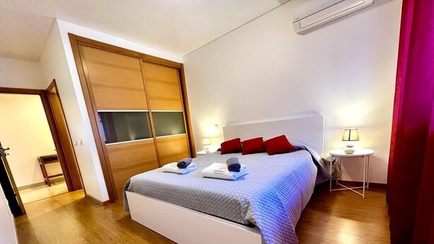 Ein Schlafzimmer mit Bett, Nachttischen und einem Kleiderschrank.