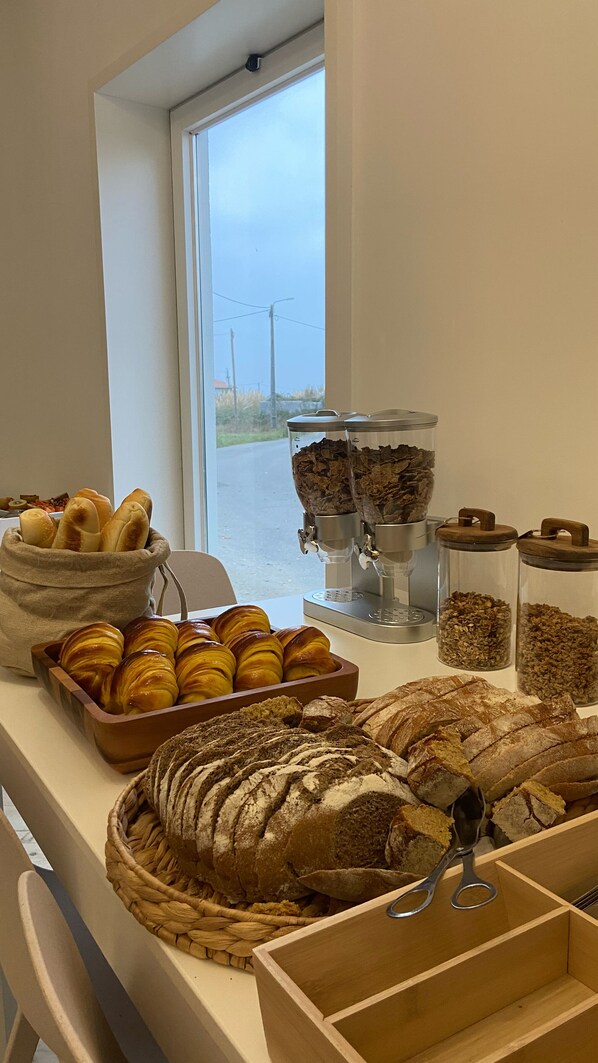 A breakfast buffet with bread, pastries, and cereal. - Tijosa Eco-House Camp (Ovar)