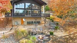 Een tweelaags landhuis met balkon en vuurkuil in de tuin.