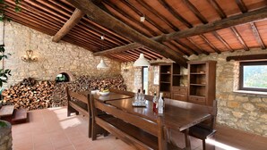 A rustic stone-walled room with a wooden table, benches, and a fireplace. - Case Domine, Radda in Chianti, Siena and Chianti (Radda in Chianti)