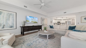 A modern living room with a sofa, coffee table, and artwork on the walls.