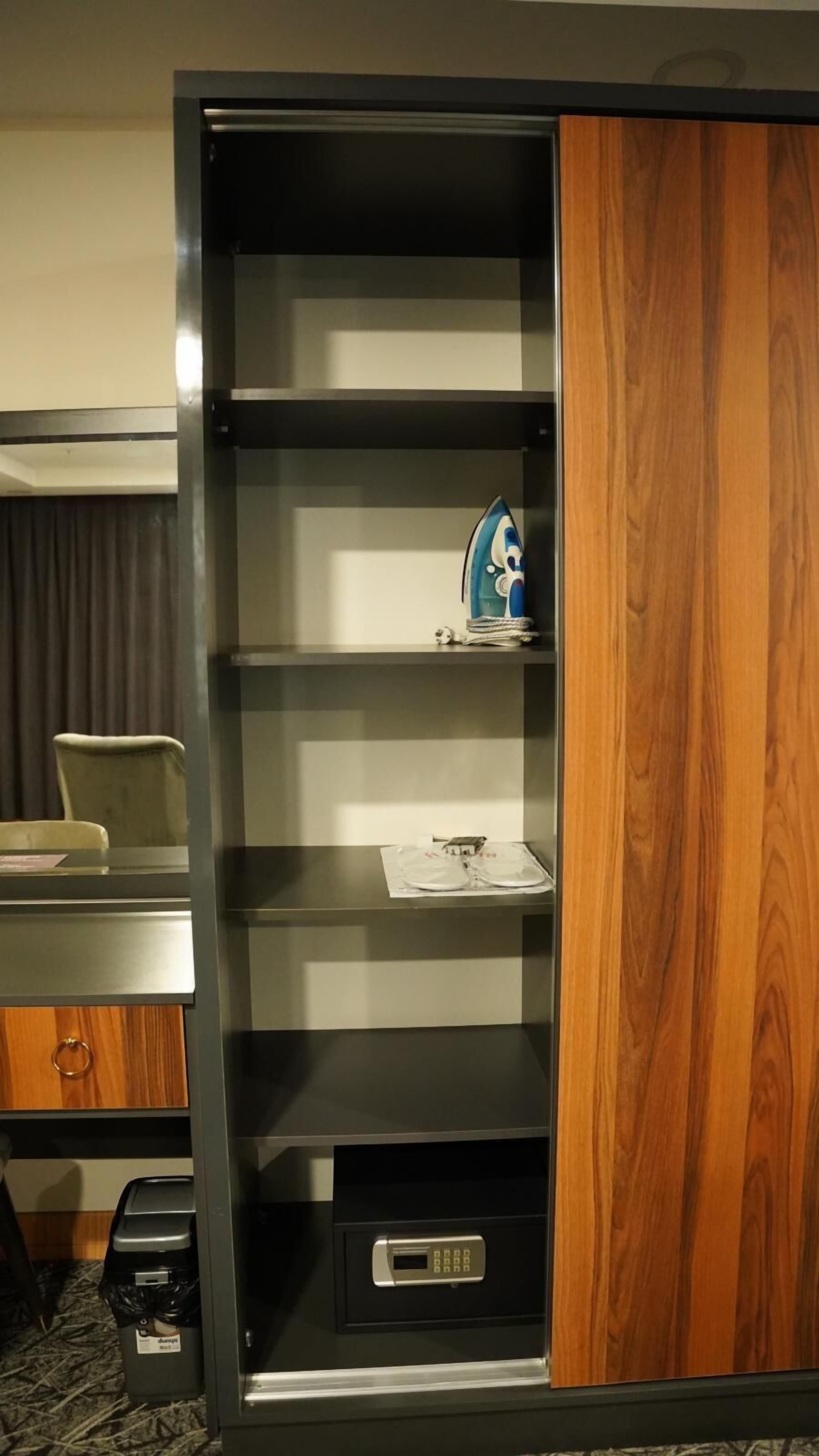 A room with a wooden cabinet, a desk, and a chair.