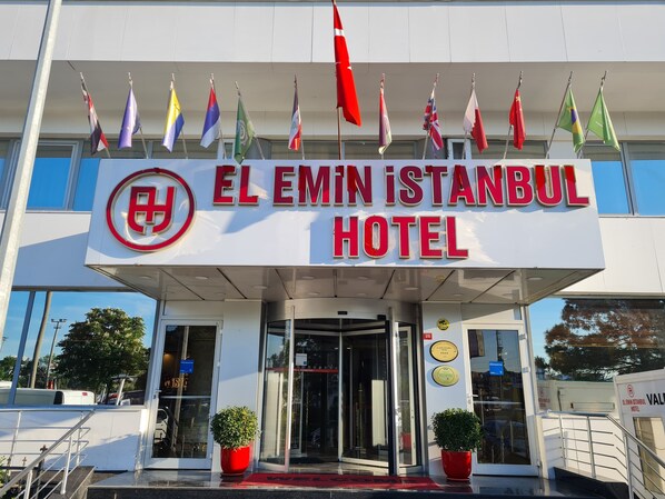 The entrance to the El Emin Istanbul Hotel with multiple flags displayed above the entrance. - El Emin İstanbul Hotel (Istanbul)