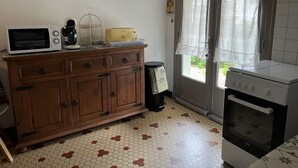 Une cuisine équipée d’un meuble en bois, d’un four à micro-ondes, d’une cuisinière et d’une poubelle.