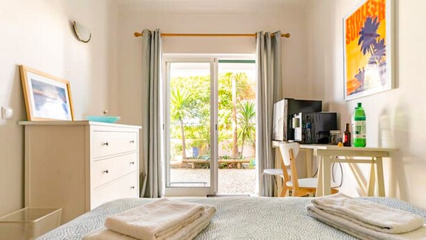 Een hotelkamer met een bed, een bureau, een stoel, een televisie en uitzicht op het omliggende landschap.