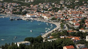 Un port marítim amb edificis residencials i un paisatge de muntanyes al fons.