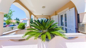 Zona exterior coberta amb una planta de palmera, un correu i una paret de pedra.