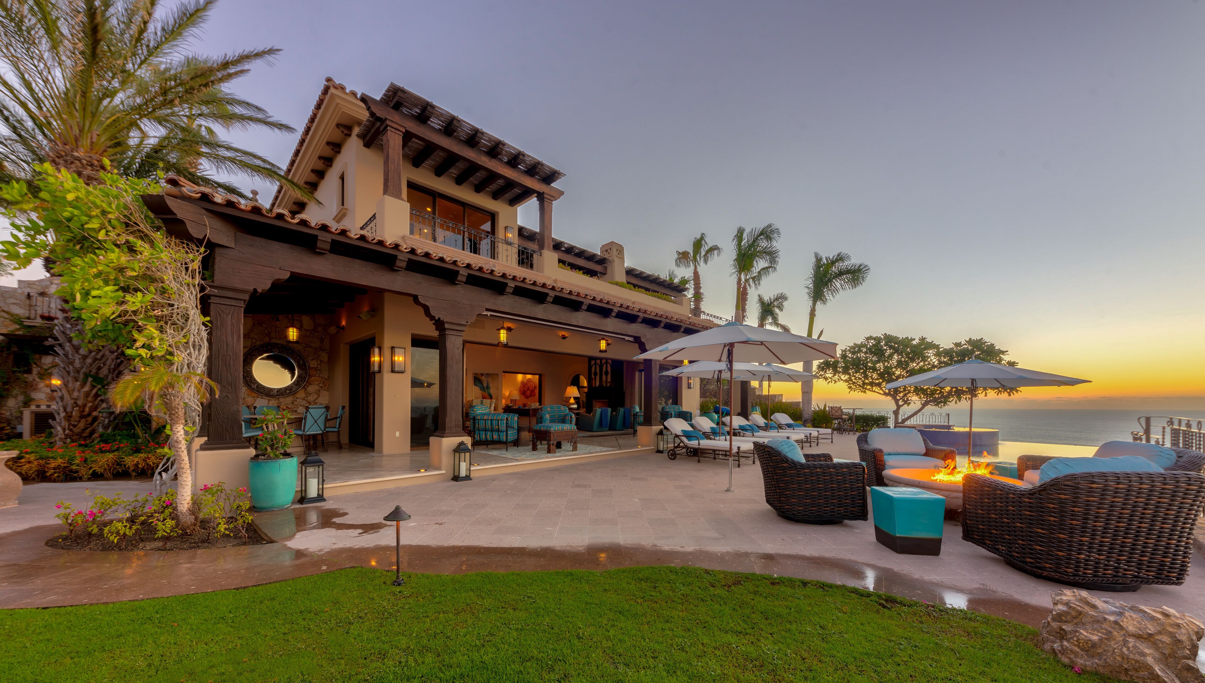 A beachfront hotel with outdoor seating and a fire feature.