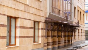 A building facade with a series of windows and a metal structure on the ground floor.