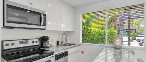 Une cuisine moderne équipée d’un four à micro-ondes, d’une cuisinière et d’un lave-vaisselle intégrés.