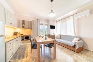 A compact living space with a kitchenette, dining area, and seating area.