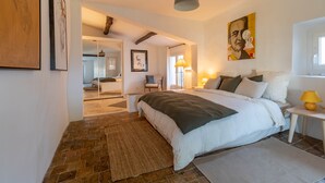 A bedroom with a large bed, a bedside table with a lamp, and a painting on the wall. - Mougins Collection - Authentic house - Old Village of Mougins (Mougins)