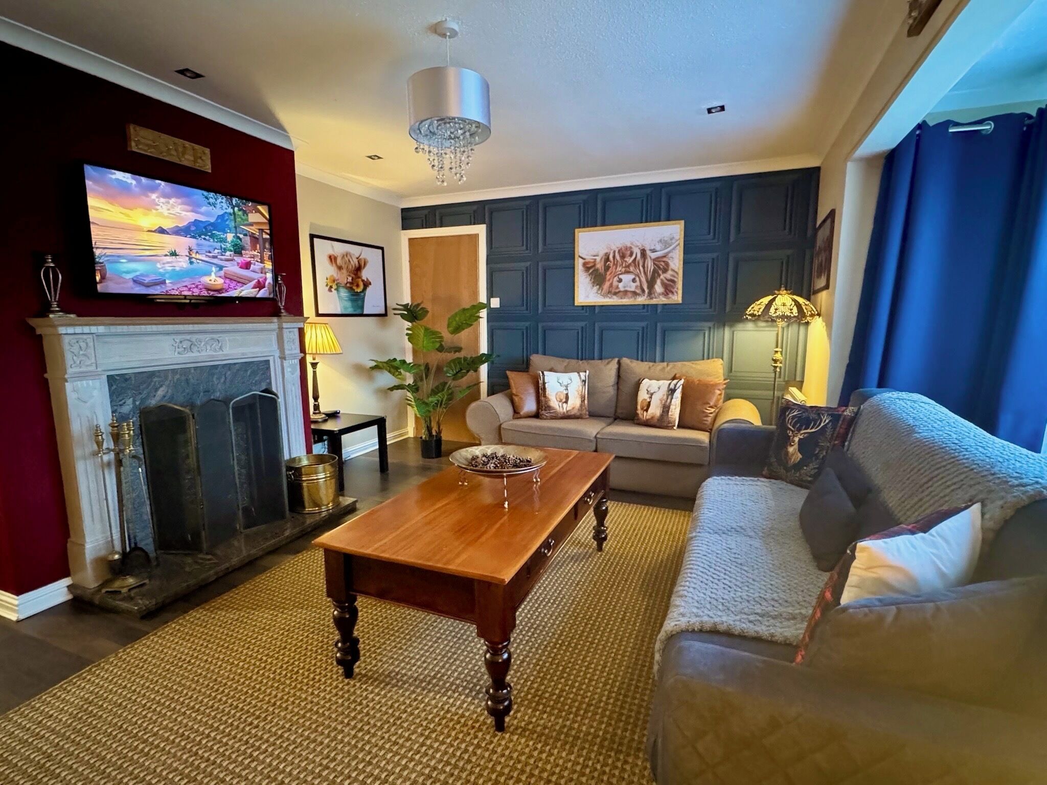 Een woonkamer met een open haard, een bank, een salontafel en een televisie.