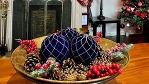 A warmly decorated living room with a fireplace, a Christmas tree, and festive decorations including a bowl of pinecones and berries. - FINN VILLAGE Mountain View Cottage Garden & XXL HOT TUB (Glasgow)