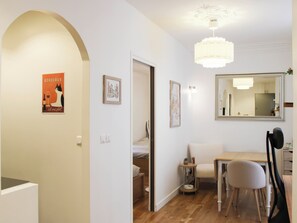 A modern interior with a dining area, a mirror, and a poster on the wall.