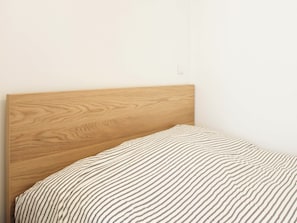 A bed with a wooden headboard and a striped bedspread.