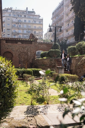 Une cour intérieure avec une arche en briques, un chemin et un petit jardin.
