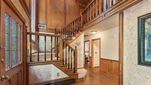 A grand staircase with wooden railings and a marble floor leading to a second floor. - Beautiful 5bd Home with Pool Near LakePoint Sports (Cartersville)