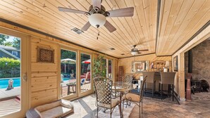 A spacious patio with a dining area, a pool, and a stone wall. - Beautiful 5bd Home with Pool Near LakePoint Sports (Cartersville)