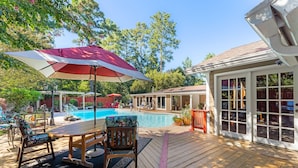 A wooden deck with a pool table, chairs, and a large umbrella. - Beautiful 5bd Home with Pool Near LakePoint Sports (Cartersville)