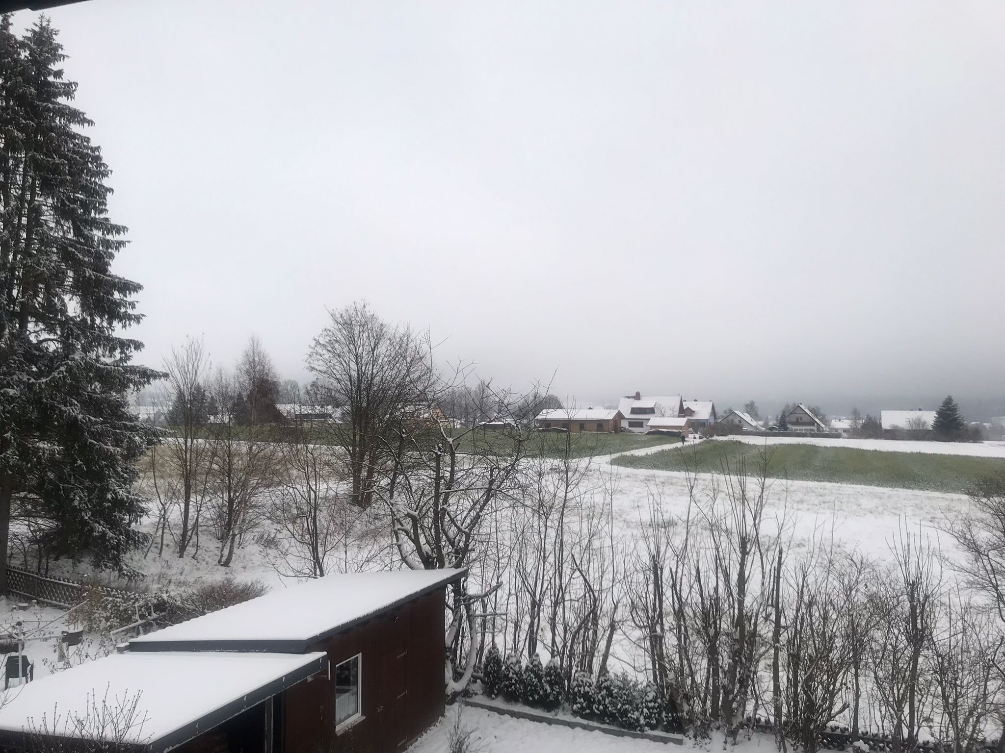 A snow-covered landscape with houses and trees.