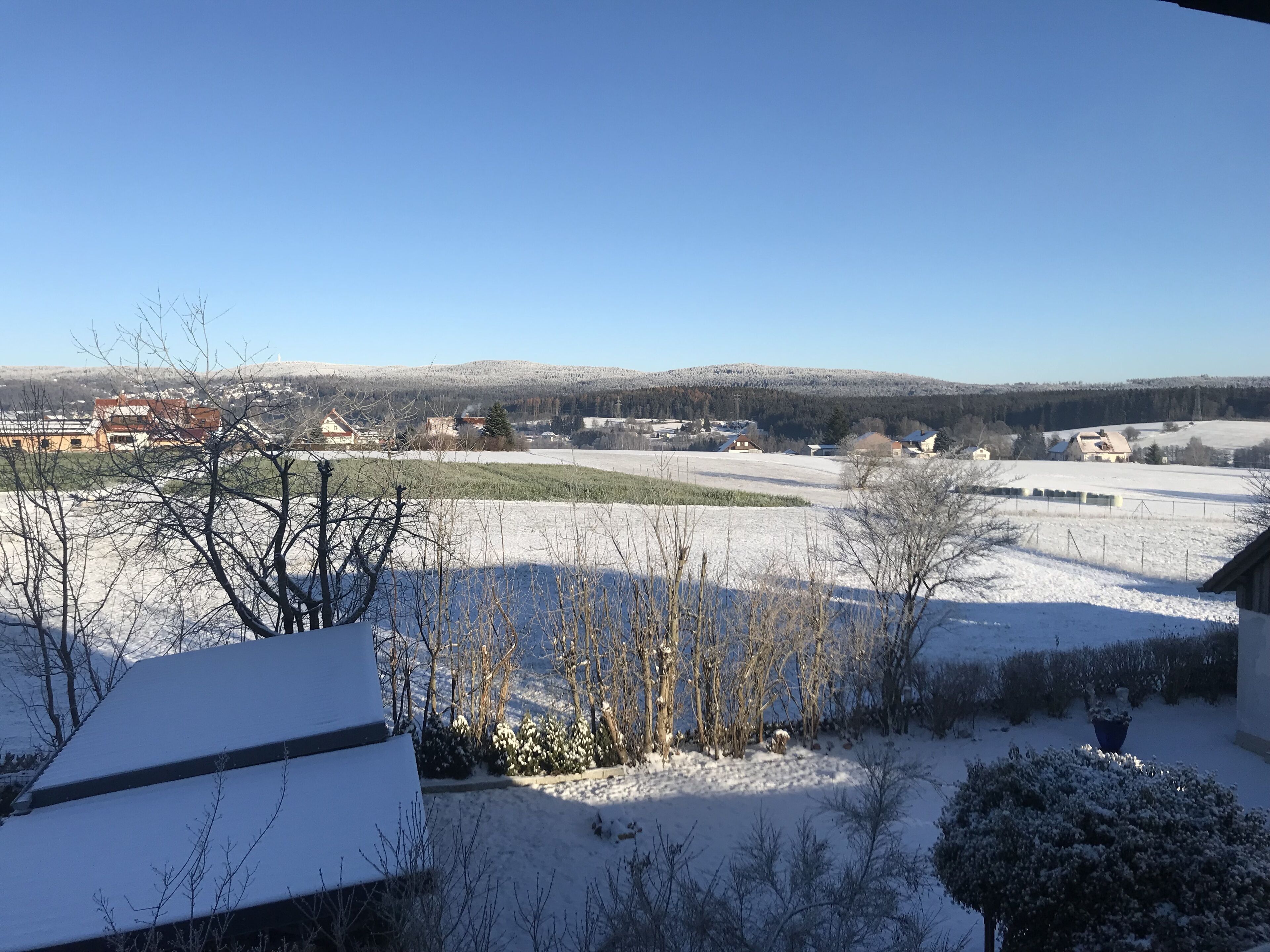 A snow-covered landscape with houses and a clear sky.