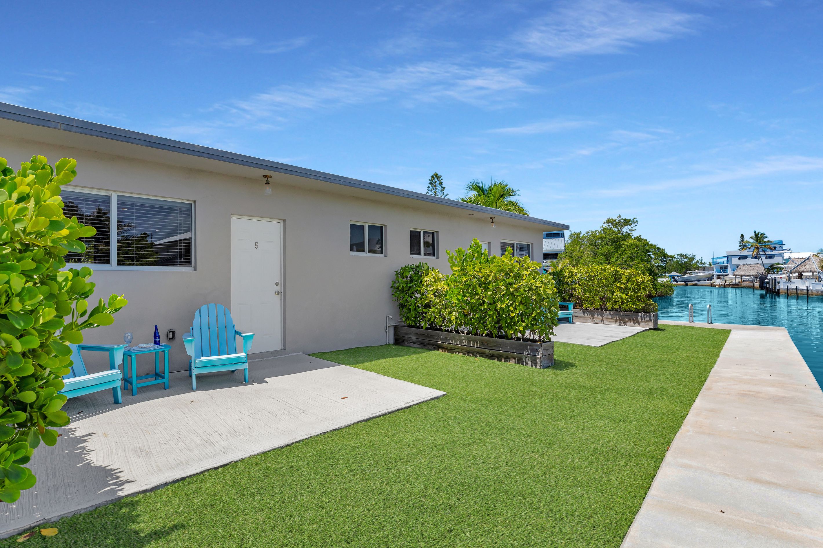 A residential property with a swimming pool, a patio with outdoor furniture, and a well-maintained lawn.