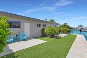 A residential property with a swimming pool, a patio with outdoor furniture, and a well-maintained lawn. - 5. Key Largo Waterfront Apartment | Reef & Relax (Key Largo)